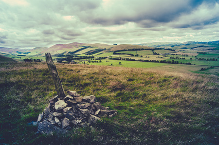 Retro Filtered Style Photo Of A Cairn On The Top Of A Hill In Scottish Landscapeの写真素材