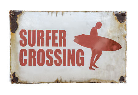 Grungy Retro Vintage Surfer Crossing Sign At A Road Crossing By A Beachの写真素材
