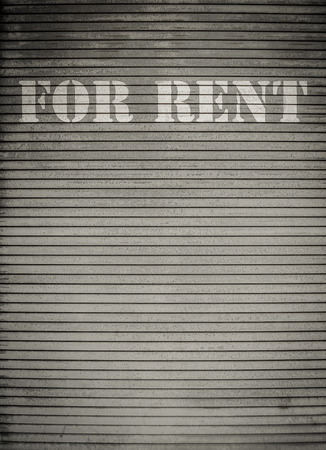 For Rent Sign On Dirty Scratched Store Roller Shuttersの写真素材