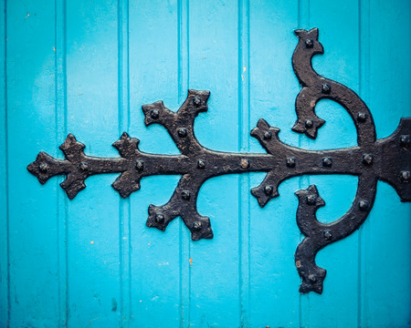 Vintage Ornate HInge On A Bright Blue Painted Church Doorの写真素材