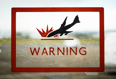 A Red Airport Security Warning Sign With Crashing Planeの写真素材