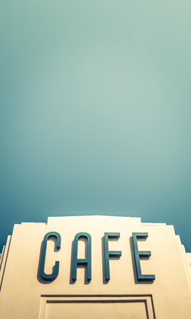A Retro Art Deco Sign For A Cafe Or Restaurant Against A Blur Sky With Copy Spaceの写真素材