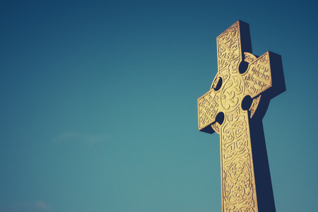 Celtic Cross Stone Gravestone Against Blue Sky With Copy Spaceの写真素材