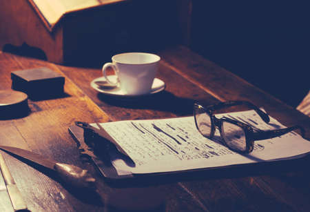 Detail Of A Writer Or Academic's Desk With Manuscript, Glasses And A Cup Of Teaの写真素材
