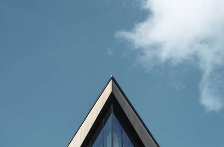 Abstract Architectural Image Of A Triangular Building Against A Blue Sky WIth Clouds And Copy Spaceの写真素材