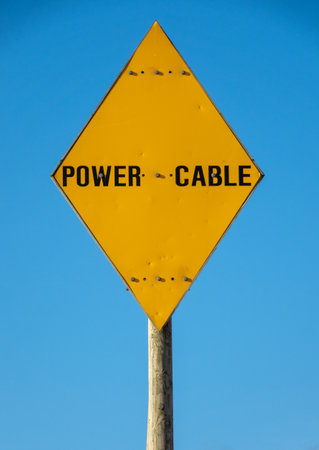 A Yellow Warning Sign For A Power Cable