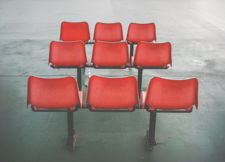 Three Rows Of Three Orange Plastic Chairs In A Waiting Areaの写真素材