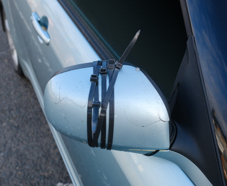 Close-Up Of A Car Side Mirror Secured With Zip Ties After Damage, Showing A Temporary DIY Repairの写真素材