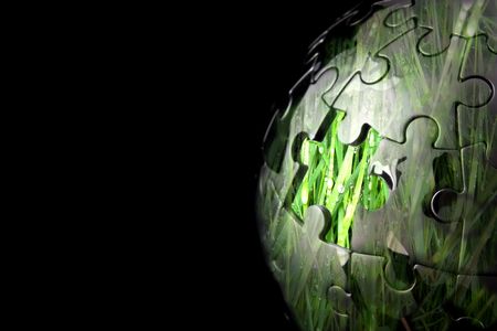 Jigsaw globe with one piece missing and grass insideの写真素材