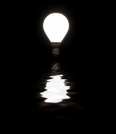 	Light bulb shining with reflection in water on blackの写真素材