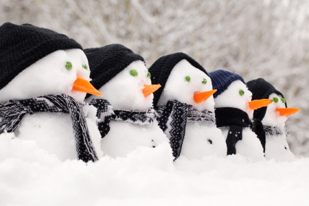 Snowmen close up in a row with hats and scarfsの写真素材