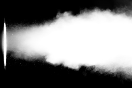 White smoke blowing through a light beamの写真素材