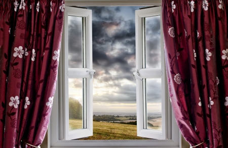 Open window onto landscape fields and cloudsの写真素材