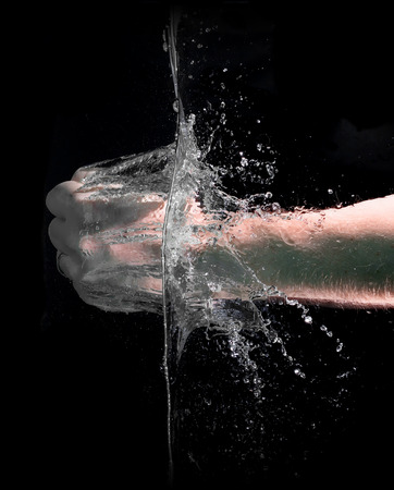 Fist punch into water with big splashes, on a black backgroundの写真素材