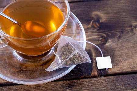 Green tea in a glass teacup on a rustic wooden tableの写真素材