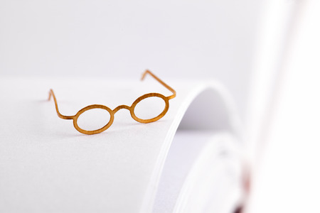 Reading glasses on a open blank book with white pages and space for textの写真素材