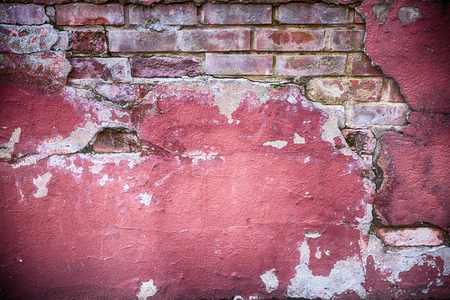 Decaying wall grunge texture. Red paint and exposed brick with plaster falling offの写真素材