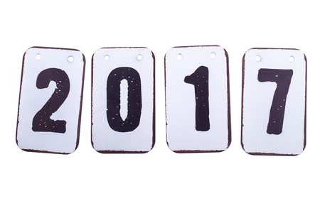 Year 2017 date in numbers made of metal tiles with hanging holes. Isolated on a white background