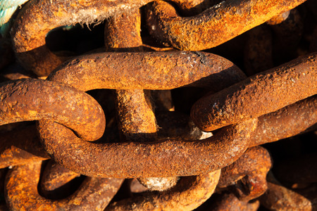 Big iron chains from an old ships anchor rusting by the harbor side close upの写真素材