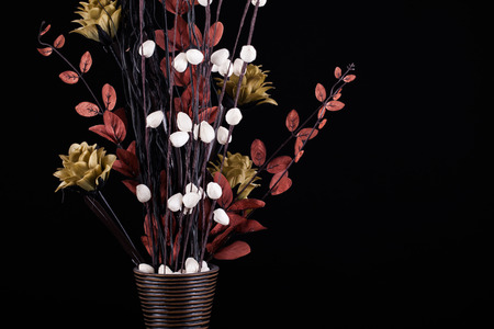 Flower arrangement in a vase with warm dark tones on a black backgroundの写真素材