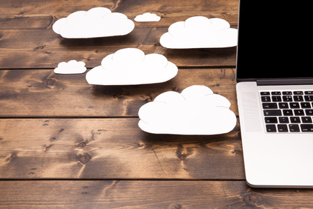Cloud computing concept laptop close up with white clouds coming out of the computer indicating...