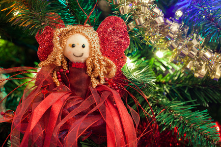 Cute Christmas tree red angel close up on a decorated Christmas treeの写真素材