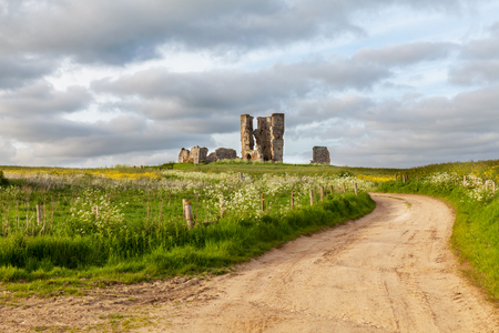Church ruin in Bawsey in Norfolk UK. Winding dusty road leading into the landscape to an ancient buildingの写真素材