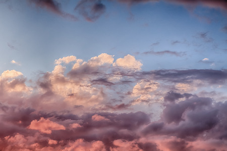 Beautiful clouds and blue sky background at sunset with pink and purple tones over England UK. Cloudscape and skyscape backdropの写真素材