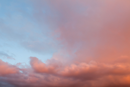 Beautiful clouds and blue sky background at sunset with pink and purple tones over England UK. Cloudscape and skyscape backdropの写真素材