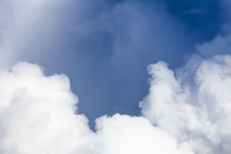 Big white puffy clouds and blue sky background. Dramatic hight detail weather pattern and texturesの写真素材