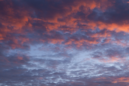 Dramatic pink sunset cloudscape with a little blue sky poking throughの写真素材