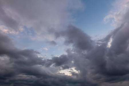 Unusual cloudy skies with dramatic grey clouds with some blue sky.の写真素材