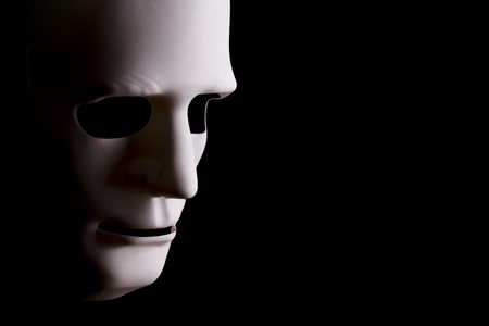 Blank robotic face mask looking sideways with a black background and copy space.の写真素材