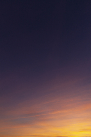 Sunset sky and wispy clouds. Orange and yellow light on cloudsの写真素材