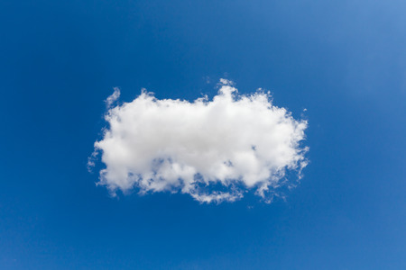 Beautiful single white cloud and blue sky background over England UK. Perfect solo cloud shape in clear skies and good weatherの写真素材