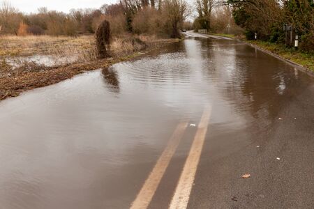 Rural road completly flooded with storm waterand double yellow linesの写真素材