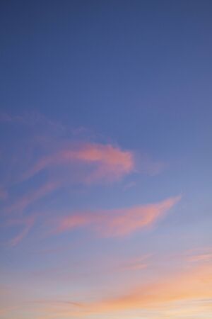 Pink sunset clouds and a blue sky backgroundの写真素材