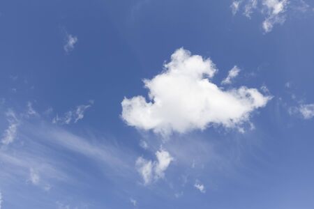 Single white cloud on a blue sky backgroundの写真素材