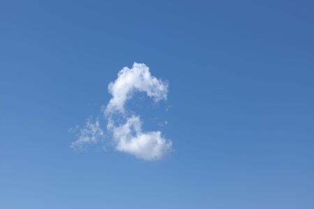 One white wispy cloud in a beautiful blue sky background. Cloudscape view on a clear day.の写真素材