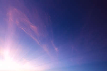 Pink wispy clouds in a blue sky sunsetの写真素材