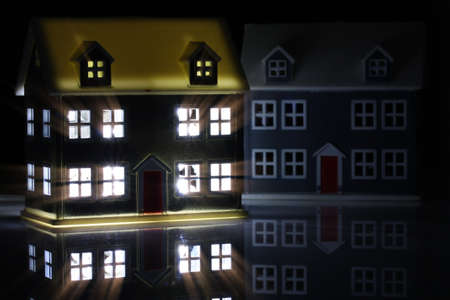 Toy house at night with the lights on indoorsの写真素材