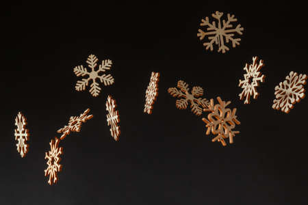Falling snowflakes cardboard cutouts in a studio photoshoot. Black background with text spaceの写真素材