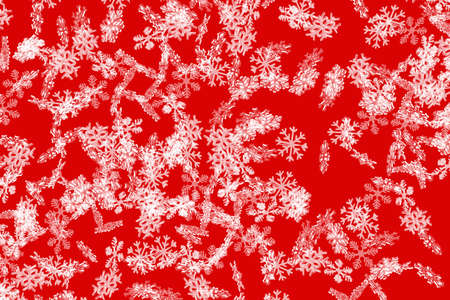 Red snowflake pattern with falling snowflakesの写真素材