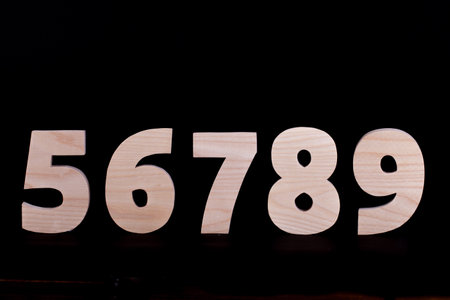 Large wooden numbers 5 6 7 8 9. Hardwood characters on a black backgroundの写真素材