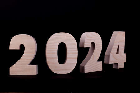 2025 year large wooden numbers curved. Hardwood characters on a black backgroundの写真素材