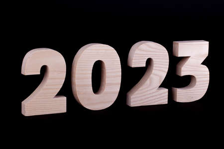 2023 year large wooden numbers. Hardwood characters on a black backgroundの写真素材