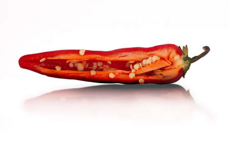 Red hot chilli pepper sliced in half close up isolated on a white background with reflectionの写真素材