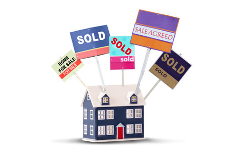 Estate agent house signs for sale and sold on a toy house isolated on a white backgroundの写真素材