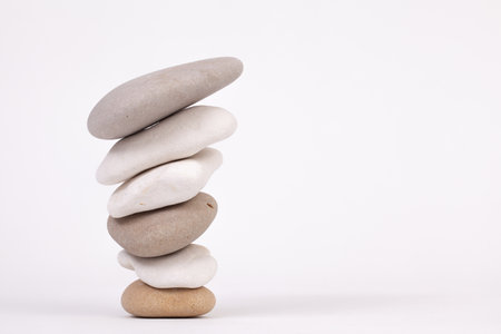 Reverse pebble zen columns with the smallest at the bottom isolated on white backgroundの写真素材