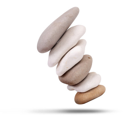 Stack of beech stones falling over isolated on a white backgroundの写真素材